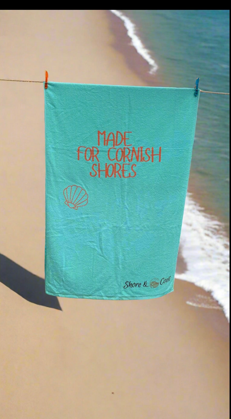 alt=“Mint green microfibre beach towel with the slogan ‘Made for Cornish Shores’ in bold white text – lightweight, quick-drying, and perfect for coastal adventures”