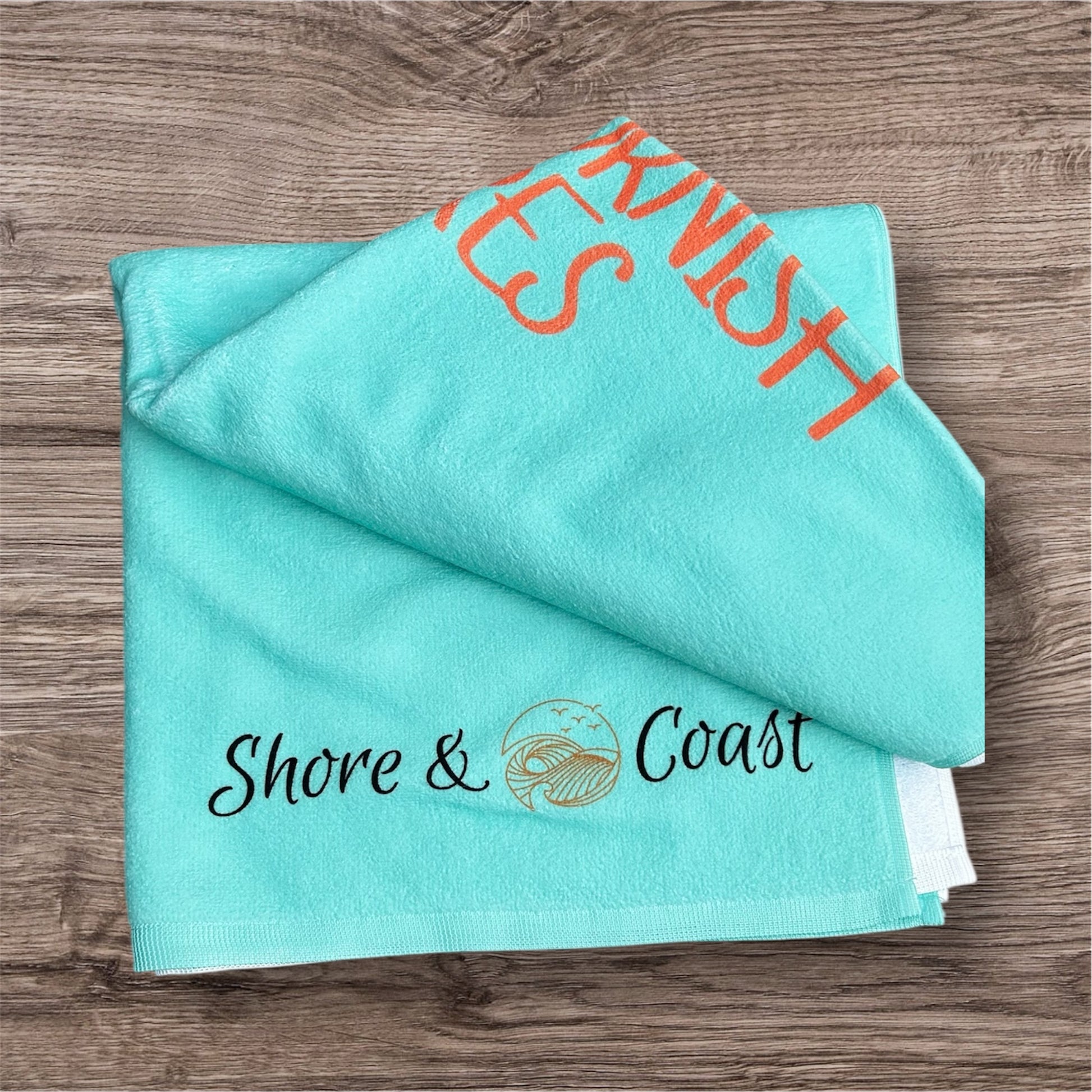 alt=“Mint green microfibre beach towel with the slogan ‘Made for Cornish Shores’ in bold white text – lightweight, quick-drying, and perfect for coastal adventures”